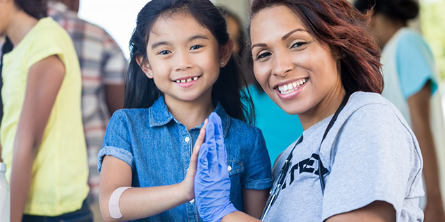 A Woman gives a high-five to a small girl.